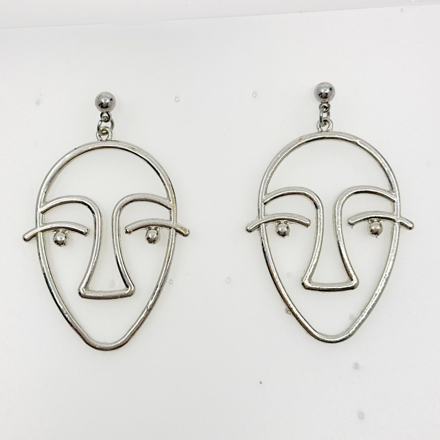 Silver tone face earrings